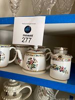Coalport bone china teapot, sugar bowl and creamer with floral decorations sitting on a shelf