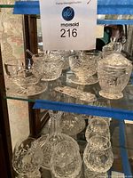Shelf display of multiple crystal bowls exhibiting leaf and diamond cut patterns