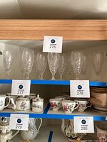 Twelve Waterford crystal glasses displayed on a shelf, showing overall quantity and shape.