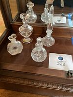 Overview of four crystal perfume bottles on wooden surface