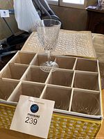 Single red crystal wine glass placed on top of the padded carrying case showing diamond cut pattern