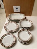 Arrangement of the partial set showing the serving platter, serving bowl, finger bowls, hors d'oeuvre plates, and soup bowls displayed on table.