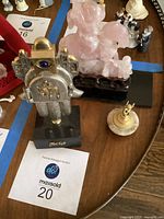 Overview of all three items: jade statue, marble paperweight with Cupid, Frank Meigler Hamsa sculpture.