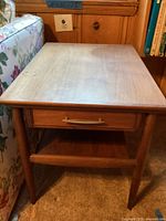 Full view of rectangular wooden side table showing top surface, drawer, legs, and lower shelf.