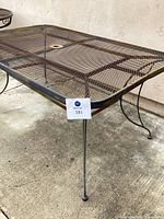 Side angle view showing metal mesh top and metal leg with rubber foot.