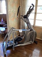 Overview of dismantled treadmill frame showing silver metal rails, base unit, handrails and console support poles.