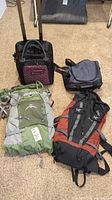 Photo showing all four items: two hiking backpacks (green Kestrel 48 and red/black Arc'teryx Bora 30), Sherpani rolling luggage, and small duffle bag on the floor.