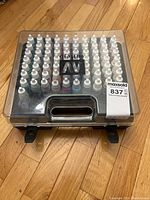 Top view of case closed showing organized paint bottles under plastic lid.