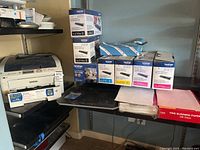 Overview showing printer unit, stacked toner cartridge boxes and printer paper