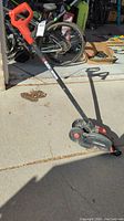Side view of the Black & Decker electric landscape edger/trencher showing handle, wheels and body.