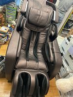 Front view of brown faux leather Infinity massage chair with integrated leg and arm massagers