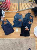Photo of all jeans and dress pants laid out on floor showing brands and sizes.