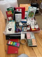 Overview of office supplies including notebooks, bubble wrap rolls, Tile trackers, scotch tape, scissors, and assorted organizers.