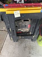 Four saw horses stacked, showing black plastic bases and attached red and yellow legs with chipped paint.