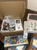 Box with papers and finger looms box plus small vintage tea set box with small plates visible