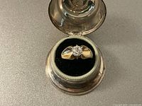 Top-down view of ring in presentation box showing diamond and band profile