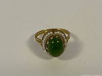 Front view of ring showing green jade cabochon and pearl halo