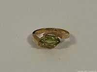 Front view of ring showing marquise-cut green peridot set in 14k yellow gold band