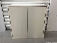 Front view of the beige IKEA storage cabinet with two doors, shows clean and good condition.