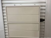 Front view of first EKET double drawer unit, beige, showing two drawers closed.