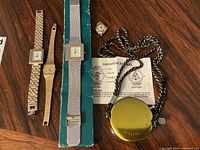 Overview photo of all watches and stopwatch arranged on table surface showing condition and accessories