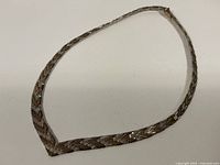 Entire necklace laid flat on white surface showing full length and shape