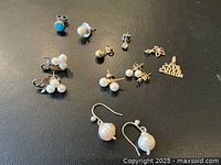 Overhead view of all eleven jewelry pieces on black background