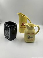 Photo of all three pitchers together: Black Bottle, J&B, and House of Lords, showing size and branding.