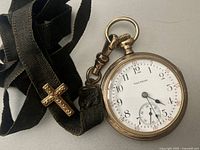 Front view of Waltham pocket watch showing white enamel dial, Arabic numerals, blued steel hands