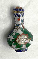Front and profile view of the small Asian cloisonné enamel snuff bottle, showing detailed floral enamel work in multiple colors with a white enamel base.