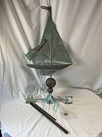 Full view of copper sailboat weathervane with directional base, rods and collar laid out