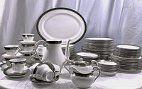 Full view of complete set arranged on table showing bowls, plates, cups, saucer stacks, platter, teapot, sugar bowl and creamer