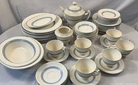Full overview of Spode Elaine set on round table showing teapot, sugar bowl, cups, saucers, plates, bowls and platters
