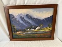Framed oil on board painting titled 'Princ Albert' showing mountains, a white house, pond, and greenery under a cloudy sky.