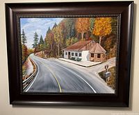Full front view of framed painting showing the road, building, trees and frame
