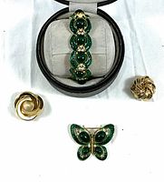 Photo showing entire jewelry set with bracelet in open black velvet case, butterfly brooch, and two gold-tone pins on white background
