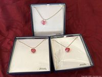 Three boxed heart-shaped crystal pendant necklaces in red and pink from Swarovski.