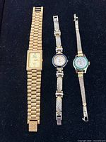 All three ladies' gold-tone wristwatches arranged vertically on black background