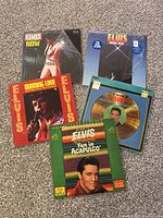 Top-down view of 5 Elvis Presley vinyl LP albums laid flat, showing colorful original sleeves with photos and titles.