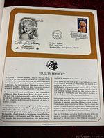First day cover envelope featuring Marilyn Monroe with original stamp and cancellation mark, accompanied by biographical text and illustration