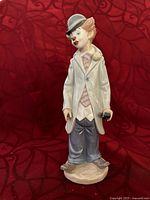 Front view of the clown figurine showing detailed face, clothing, and violin held behind the back.