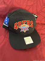 Front view showing embroidered 49ERS logo with Super Bowl XXIX patch and official holographic sticker on brim.