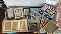 Overview of all 12 frames set including the digital photo frame in box and 11 assorted frames of various colors and materials