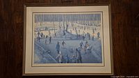 Full view of the framed print showing the winter scene with multiple ice skaters among trees in a forest setting.