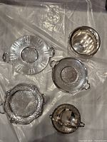 Top-down view of all five pieces showing ornate and simple designs, and open top wine holder