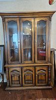 Full front view of the traditional wood veneer china cabinet with glass doors, showing upper and lower sections with storage.