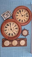Image showing the full set of five vintage items including two wooden Bulova clocks, a small metal desk clock, ship wheel barometer, and wooden weather panel with three dials.