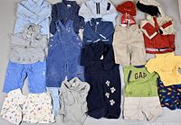Full lot overview with all 22 baby clothing items spread out flat on a surface.