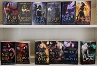 Photo showing 12 fantasy romance paperback novels with cover art featuring mystical and supernatural themes and characters.