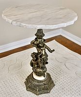 Full view of marble top and cherub base against neutral background